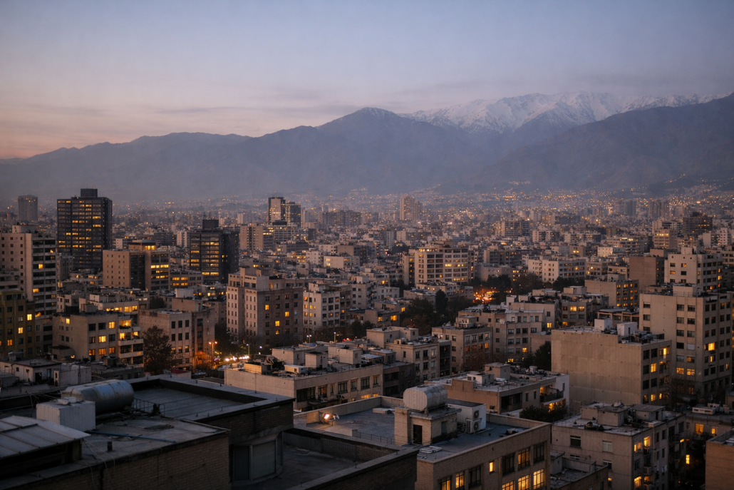 A wide aerial view of central Tehran at dusk showing dense urban blocks and high-rise office towers in the financial district