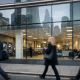 A Barclays bank branch facade on a UK high street with pedestrians walking past