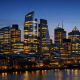 The financial district skyline of London at dusk with illuminated office towers housing global investment banks