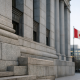 Exterior of a Canadian bank building with the national flag, representing a Bank of Canada interest rate decision