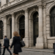 A bank facade in an Italian financial district under natural daylight, representing the Monte dei Paschi shareholder decision
