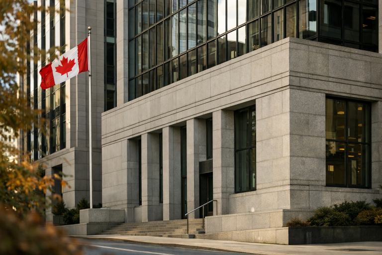 A modern Canadian bank facade with the national flag visible, photographed at eye level on a bright autumn day