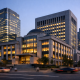 Exterior of a central bank headquarters building in Seoul with a modern financial district skyline