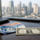 Philippine peso banknotes beside a US dollar bill against a city skyline, illustrating the currency's record low against the dollar